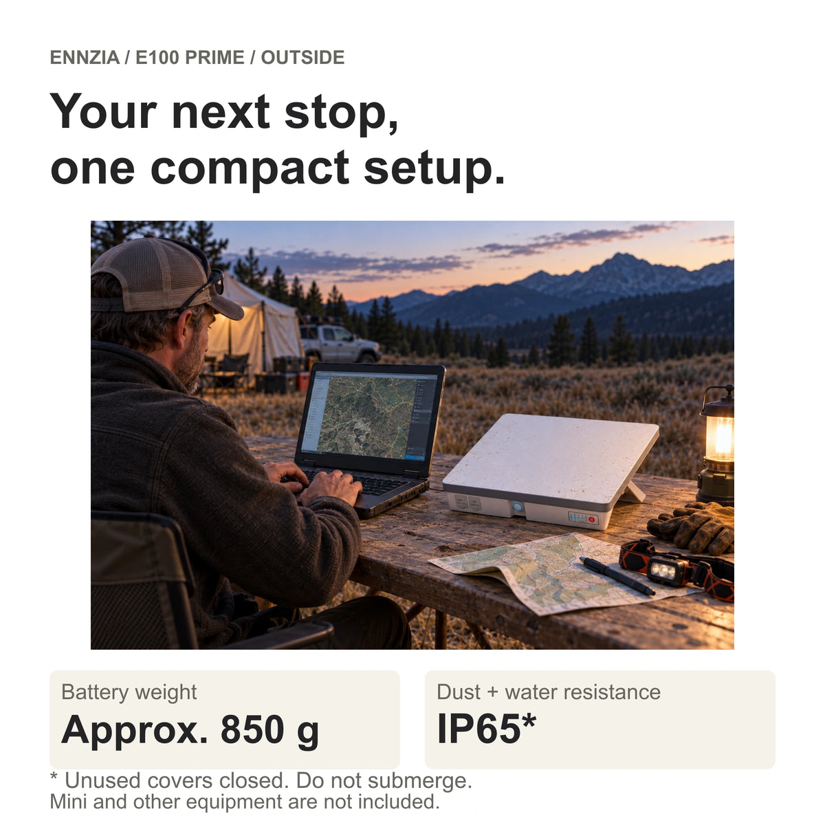In use — Illustrative camp workspace with a person using a laptop beside Mini and its battery